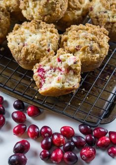 cranberry muffins on a cooling rack next to fresh cranberries