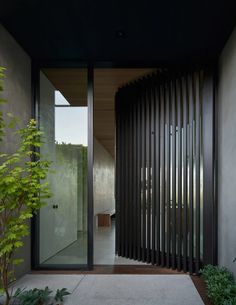 an entrance to a modern home with black slats