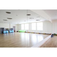 an empty room with mirrors and exercise balls on the floor in front of it,