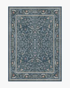 a blue rug with an ornate design on the center and sides, in various colors