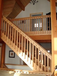 a living room filled with furniture and wooden stairs