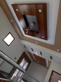 an overhead view of a stairwell with glass railings and wood paneling on the ceiling