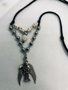 "Dije de la Santa Muerte Plateada con bolas de acero inoxidable platada y craneo blanca terminado en collar con hilo de cordon grueso negro Collar ajustable con cierre minimo desde 16\" pulgadas como collar gargantilla y expandible hasta 28\" pulgadas como collar Material: Santa Muerte plateada con alas Metal rustico 3 cm craneo blanca 6mm bolas de acero inoxidable plateada 6mm, 3mm con cadena de acero inoxidable hilo de cordon grueso color negro Personalizamos el color del cordon, preguntenos!! Silver Skull Stainless Steel Jewelry, Silver Stainless Steel Skull Jewelry, Adjustable Silver Punk Jewelry, Silver Adjustable Skull Necklace, Adjustable Silver Skull Necklace, Skull Shaped Silver Jewelry For Festival, Silver Skull Shaped Festival Jewelry, Silver Skull Jewelry For Festivals, Designer Wishlist