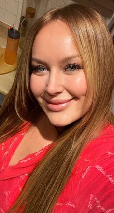 a woman with long brown hair smiling at the camera