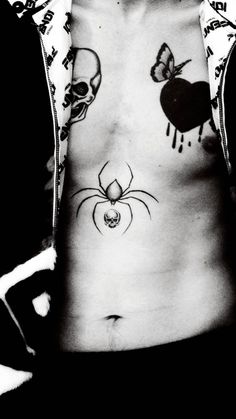 black and white photograph of a man with tattoos on his stomach, wearing a spider costume