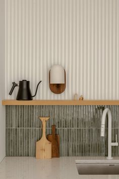 a kitchen with a sink, cutting board and tea kettle on the counter top next to it