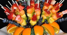 an arrangement of fruit is arranged on sticks