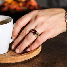 a close up of a person's hand near a cup of coffee