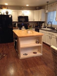 a kitchen with white cabinets and wood floors