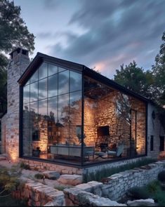 a glass walled house is lit up at night