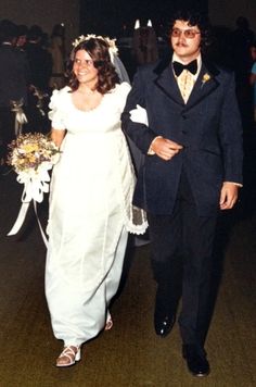 a bride and groom are walking down the aisle at their wedding reception in an old photo