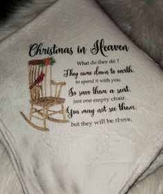 a white blanket with a rocking chair embroidered on it and the words, christmas in heaven