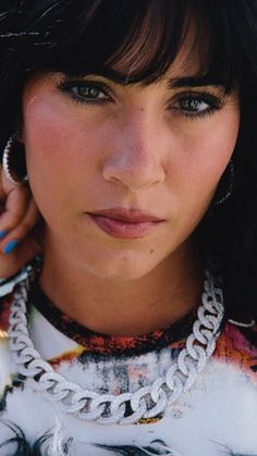 a close up of a person wearing a necklace and earring with feathers on it