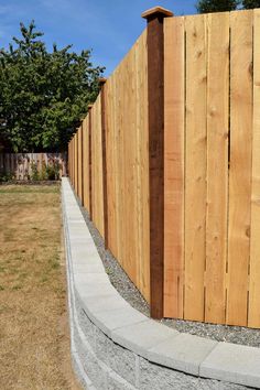 a long wooden fence next to a grassy field