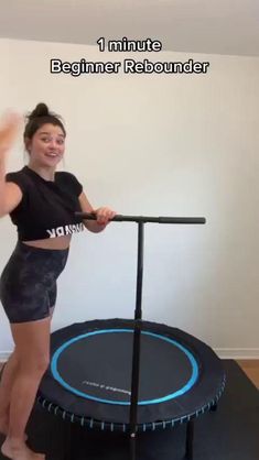 a woman standing on top of a black trampoline