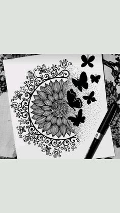 a black and white drawing of a sunflower with butterflies on it, next to a marker pen