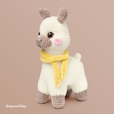 a crocheted stuffed llama wearing a yellow scarf