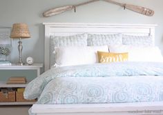 a white bed topped with a blue comforter and pillows