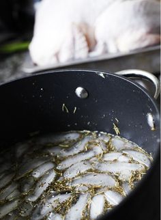 the food is being cooked in the pan on the stove top with someone's hand