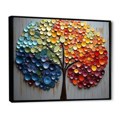 a colorful tree made out of bottle caps is displayed on a white wall with wood planks