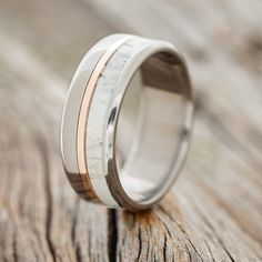 a wedding band with two tone gold inlays on an old wooden surface,