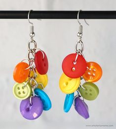 two pairs of colorful button earrings hanging from hooks