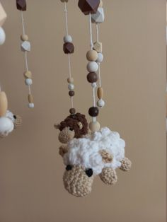 a crocheted sheep mobile hanging from the ceiling