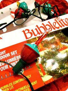 a red light sitting on top of a magazine next to some christmas decorations and glasses