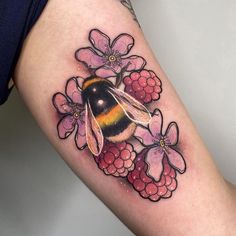 a woman's thigh with a bee and flowers on it