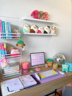 a desk with a computer, books and stuffed animals on it's shelfs