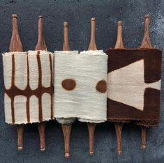 four wine bottles are lined up in the shape of toothbrush holders with brown and white designs on them