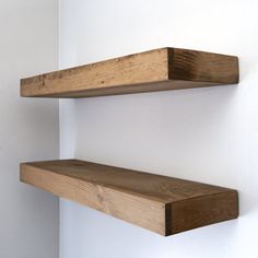 two wooden shelves mounted to the side of a wall next to each other on a white wall