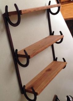 three wooden shelves with black iron brackets on the wall next to each other in a kitchen