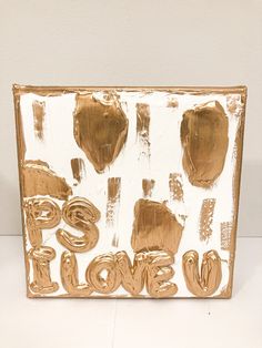 a painting with gold paint on it that says love