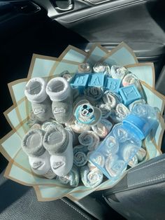 a bunch of baby items sitting on top of a car seat in front of a steering wheel