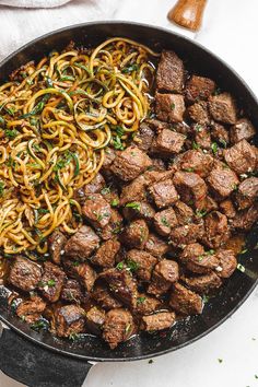 a pan filled with meat and noodles on top of a table next to an instagram page