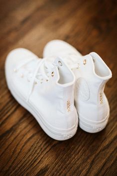 two white shoes sitting on top of a wooden floor