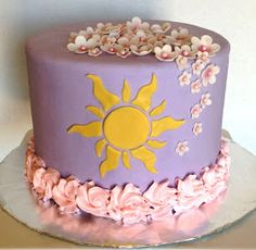 a purple and yellow cake with flowers on it