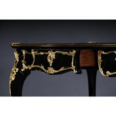 a black and gold decorated table with drawers