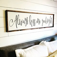 there is a sign that says always kiss me goodnight on the wall above the bed