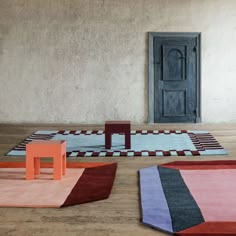 three different colored rugs on the floor in front of an open door and chair