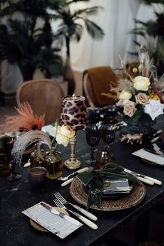 the table is set with place settings and flowers