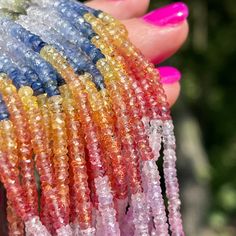 a hand holding several different colored beads