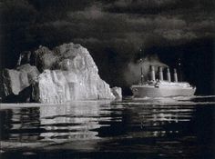 an iceberg floating in the ocean next to a boat