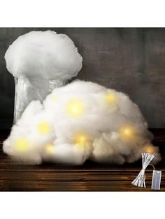 a white cloud with lights on it sitting on top of a wooden table