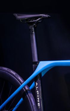 the front end of a blue bike against a black background