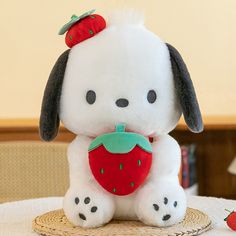 a stuffed animal sitting on top of a table next to a strawberries strawberry pillow