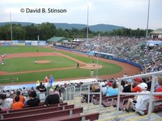 a baseball game is being played in a stadium with people sitting on the bleachers