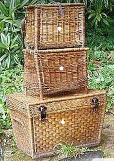 three wicker baskets stacked on top of each other in front of some bushes and trees