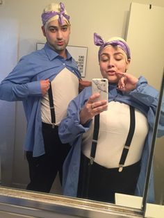 a man and woman dressed up as pregnant women taking a selfie in the mirror